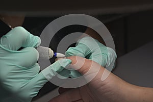 Woman hands receiving a manicure in beauty salon. Nail filing. Close up, selective focus