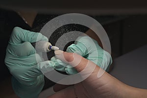 Woman hands receiving a manicure in beauty salon. Nail filing. Close up, selective focus