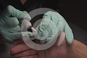 Woman hands receiving a manicure in beauty salon. Nail filing. Close up, selective focus