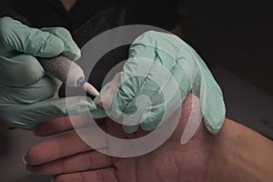 Woman hands receiving a manicure in beauty salon. Nail filing. Close up, selective focus