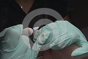 Woman hands receiving a manicure in beauty salon. Nail filing. Close up, selective focus
