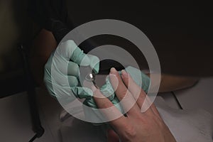 Woman hands receiving a manicure in beauty salon. Nail filing. Close up, selective focus