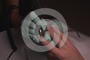 Woman hands receiving a manicure in beauty salon. Nail filing. Close up, selective focus