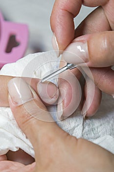 Woman hands receiving manicure and nail care procedure. Close up concept. Manicurist pushing cuticles on female`s nails