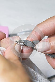 Woman hands receiving manicure and nail care procedure. Close up concept. Manicurist pushing cuticles on female`s nails