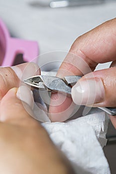 Woman hands receiving manicure and nail care procedure. Close up concept. Manicurist pushing cuticles on female`s nails
