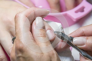Woman hands receiving manicure and nail care procedure. Close up concept. Manicurist pushing cuticles on female's nails. female