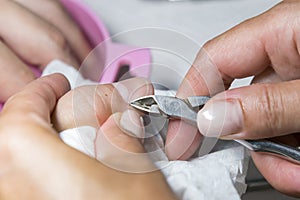 Woman hands receiving manicure and nail care procedure. Close up concept. Manicurist pushing cuticles on female's nails. female