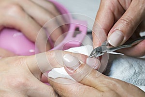 Woman hands receiving manicure and nail care procedure. Close up concept. Manicurist pushing cuticles on female`s nails. female