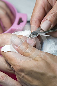 Woman hands receiving manicure and nail care procedure. Close up concept. Manicurist pushing cuticles on female`s nails. female