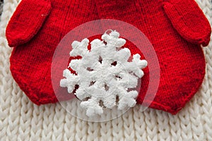 Woman hands in red gloves holding white big snowflake
