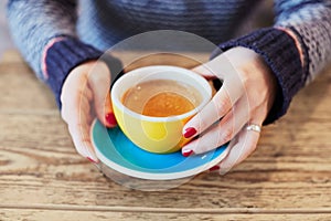 Woman hands with red manicure and cup of coffee