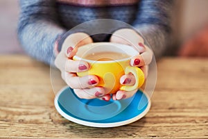 Woman hands with red manicure and cup of coffee