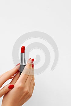 Woman Hands with Red Manicure Holding Red Lipstick. Isolated On White Background