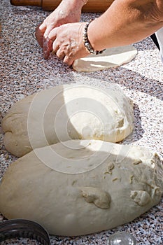 Woman hands rolling dough with rolling pin, making pies or pizza bread, homemade