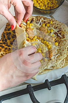 Woman hands rolling mexican fajita on the plate