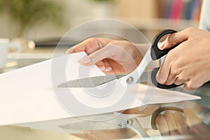 Woman hands with scissors cutting paper on a desk