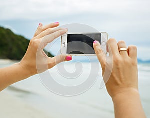 Woman hands showing a blank smart phone screen display on the be
