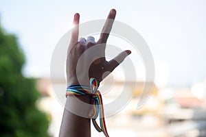 Woman hands showing love sign with LGBTQ Rainbow ribbon in the morning for Lesbian, Gay, Bisexual, Transgender and Queer community photo