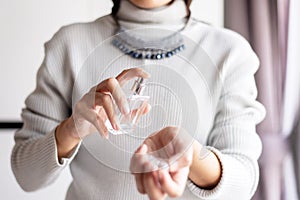 Woman hands spraying favorite perfume at home,Applying perfume is the simplest of matters