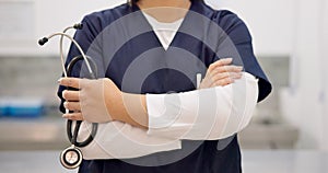 Woman, hands and stethoscope of professional doctor with arms crossed in healthcare or medical service at hospital