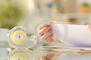 Woman hands sticking adhesive tape on a paper