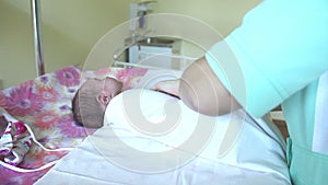 Woman hands are swaddling a newborn girl.