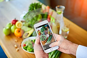 Woman hands take smartphone food photo of vegetables salad with tomatoes and fruits. Phone photography for social media or