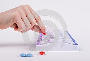 Woman hands taking pills from case or sorting tablets and vitamins for daily medication. Health care concept