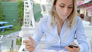 Woman hands texting on smartphone during breakfast in cafe