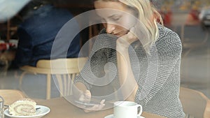 Woman hands texting on smartphone during breakfast in cafe