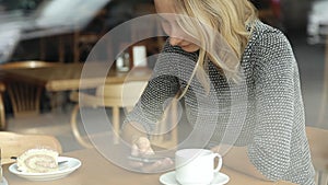 Woman hands texting on smartphone during breakfast in cafe