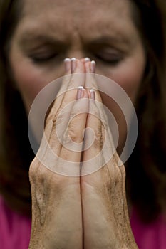 Woman with hands together as if praying