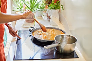 Woman hands touching ceramic hob cooking Spanish paella