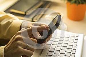 Woman hands touching smartphone and keyboard