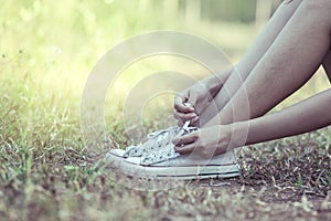 Woman hands tying lace her old shoes ready for travel