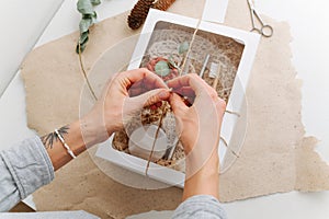 Woman hands tying windowed box with multi-use eco-friendly items