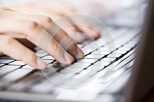 Woman hands typing on laptop keyboard