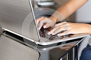 Una mujer manos escribiendo en computadora portátil en negocios sobre el 