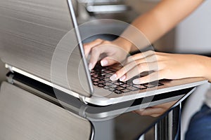 Woman hands typing in a laptop working at home