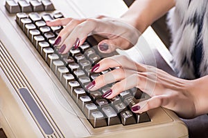 Woman hands typing on old computer keyboard