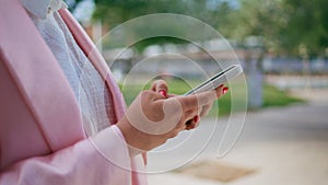 Woman hands typing smartphone on street close up. Fingers writing mobile phone