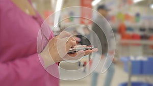 Woman hands using mobile phone in Department store :