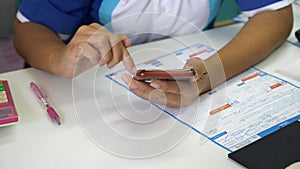 Woman Hands Using Mobile Phone Doing Calculation in Auto Service Workshop