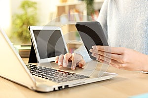 Woman hands using multiple devices at home