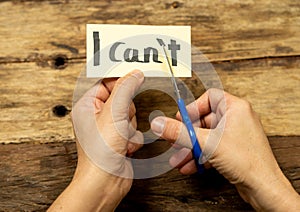 Woman hands using scissors to remove letter T from written text I can`t do it to read I can