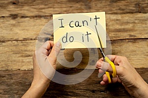 Woman hands using scissors to remove letter T from written text I can`t do it to read I can