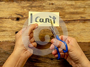 Woman hands using scissors to remove letter T from written text I can`t do it to read I can