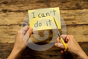 Woman hands using scissors to remove letter T from written text I can`t do it to read I can