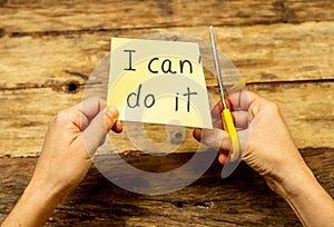 Woman hands using scissors to remove letter T from written text I can`t do it to read I can